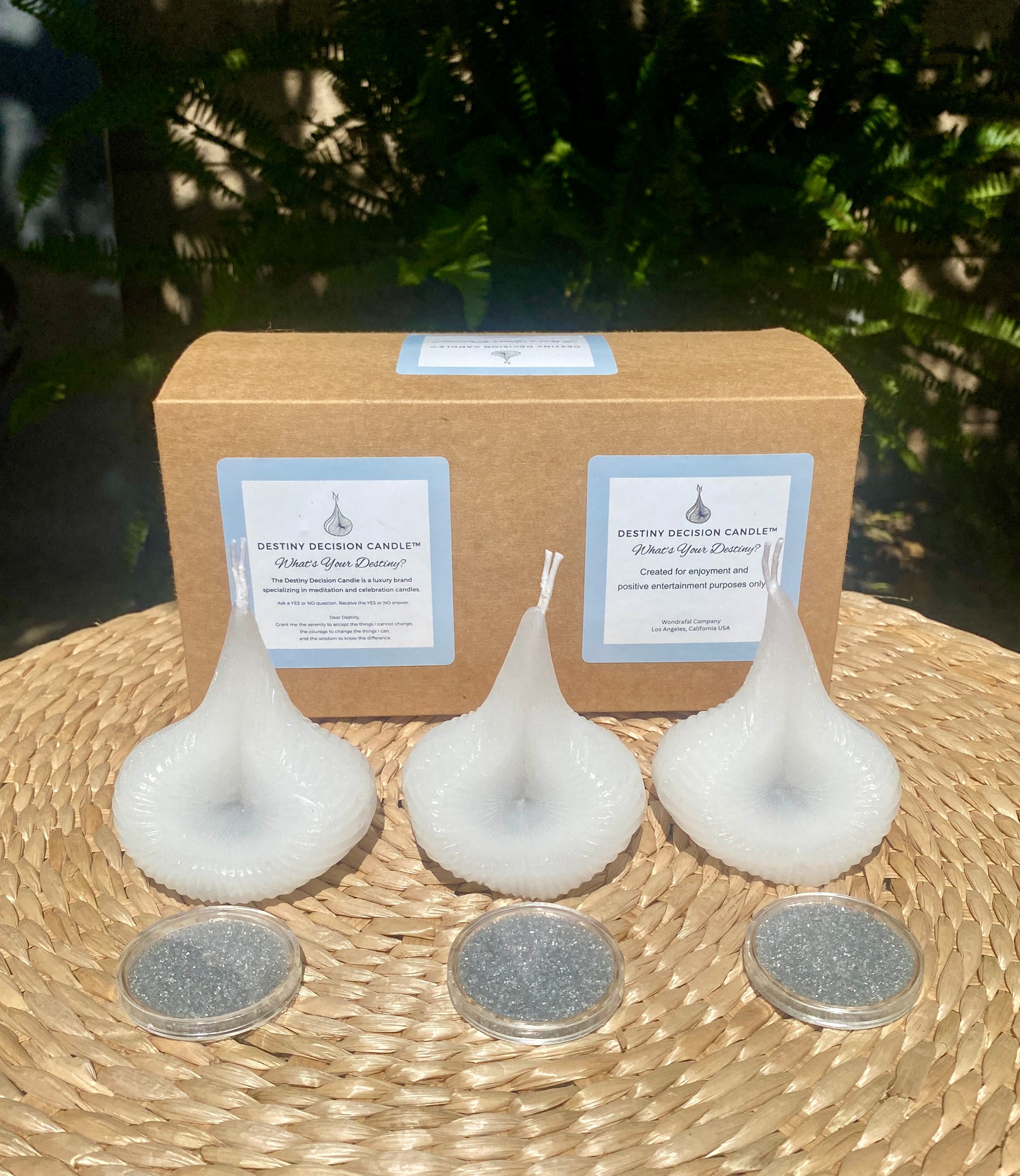 The White Trio Destiny Decision Candles set and Destiny Sparkles on natural wicker table with green leafy outdoors background.

What’s your destiny?  A Destiny Decision Candle Trio box.  Natural Ecco friendly brown paper square box with light blue and white labels and black font.  The Destiny Decision Candle logo.  What’s your destiny? 