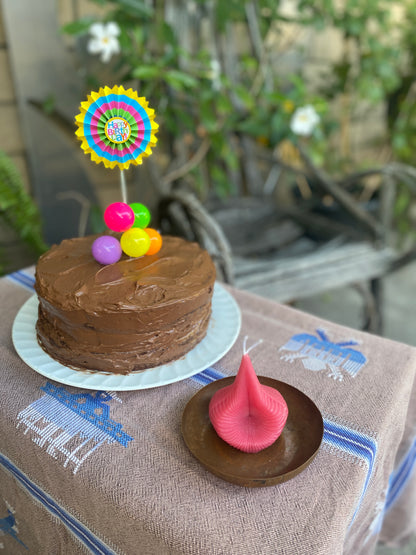 Pink Destiny Decision Candle on a copper bowl with a big two layer chocolate birthday cake.